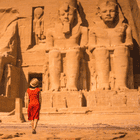 Visitor at Abu Simbel, Egypt, admiring the magnificent colossal statues of Ramses II, a breathtaking experience with DMC Egypt.