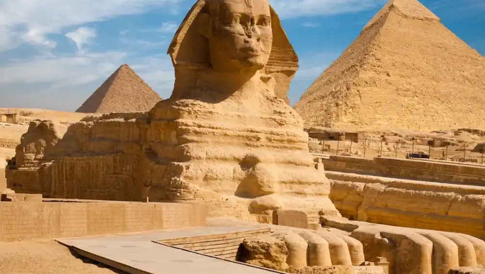 Sphinx and Pyramids in Giza, Egypt under clear sky.